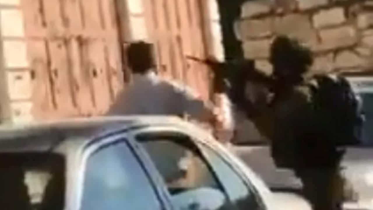 Photo of the Palestinian father and son being harassed by IDF soldiers