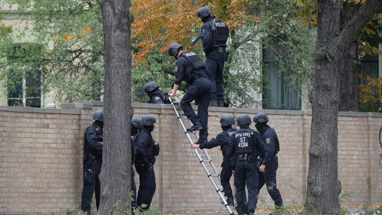 Photo of police officers crossing a wall