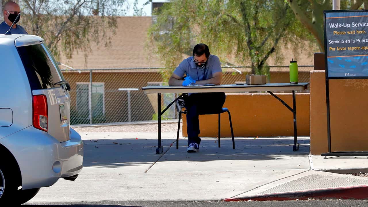 Photo of a man waiting to check out books curbside 