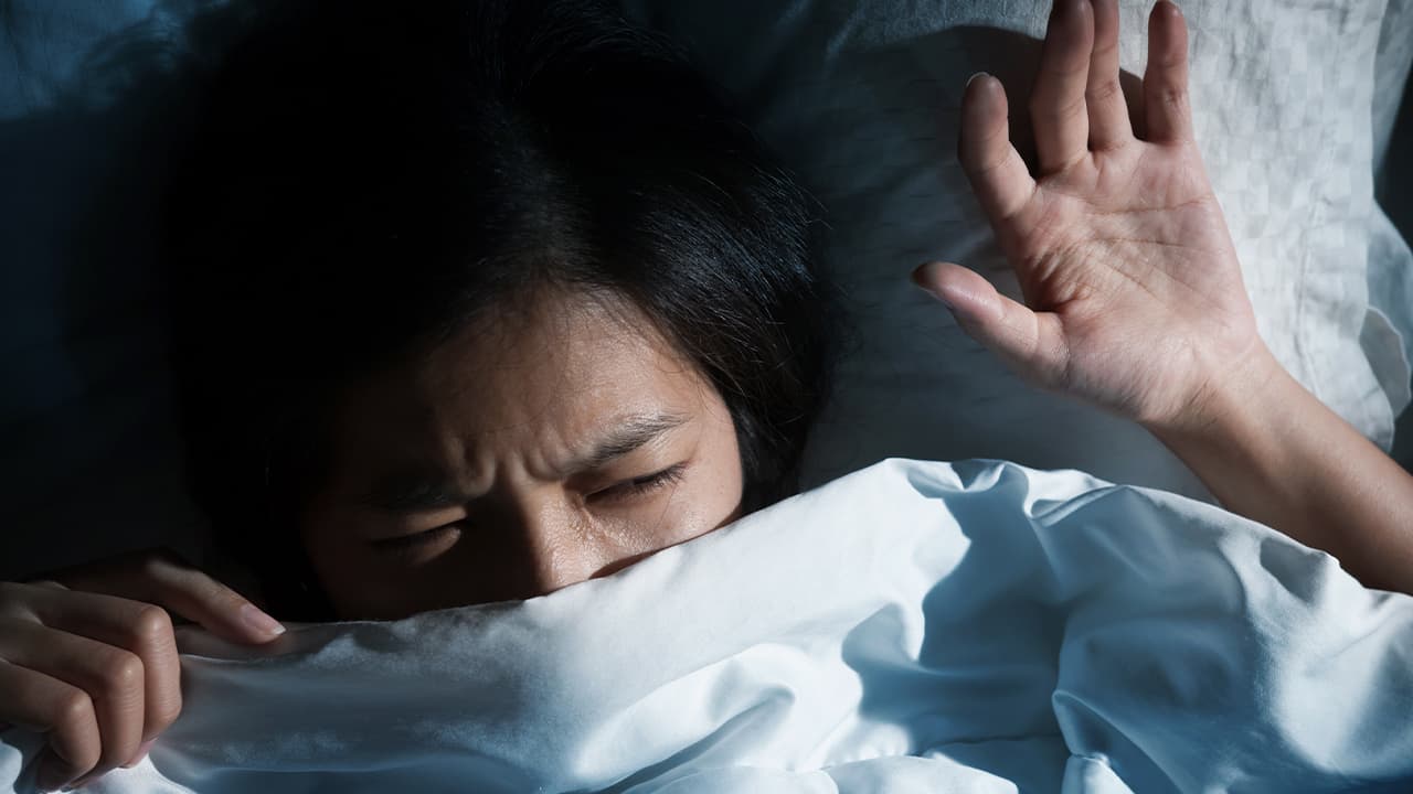 Photo of a girl waking up from a bad dream