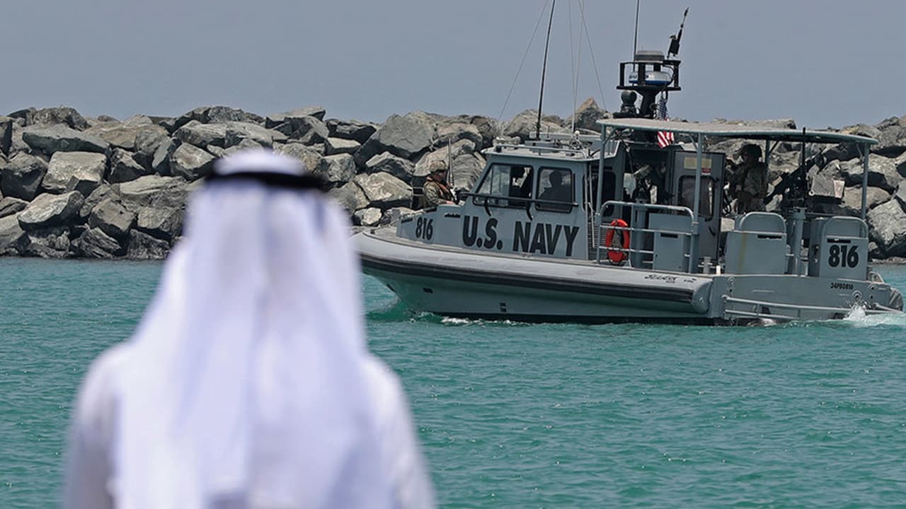 Photo of a Navy patrol boat carrying journalists see damaged oil tankers