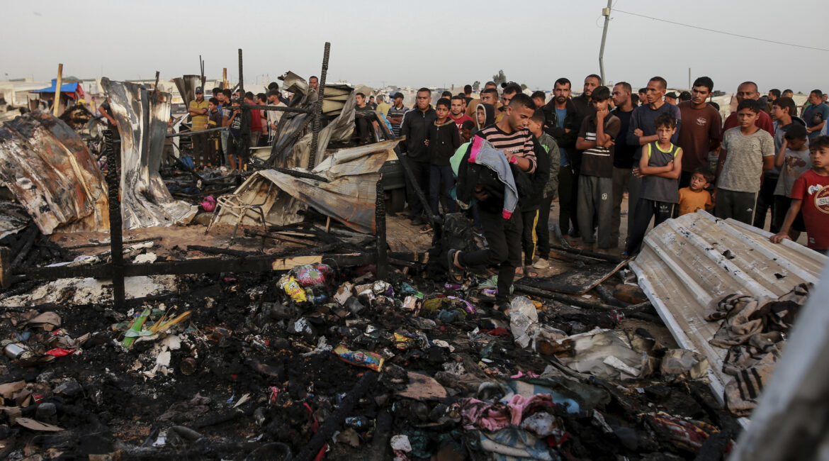 Palestinians look at the destruction after an Israeli strike where displaced people were staying in Rafah, Gaza Strip, Monday, May 27, 2024. Palestinian health workers said Israeli airstrikes killed at least 35 people in the area. Israel's army confirmed Sunday's strike and said it hit a Hamas installation and killed two senior Hamas militants. (AP Photo/Jehad Alshrafi)