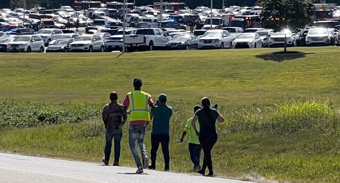 Students are evacuated to the football stadium after the school campus was placed on lockdown at Apalachee High School in Winder, Ga., on Wednesday, Sept. 4, 2024. (Erin Clark via AP)