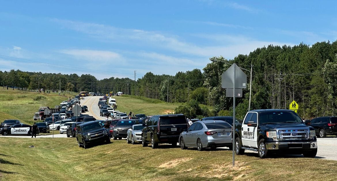 Law enforcement arrive as students are evacuated to the football stadium after the school campus was placed on lockdown at Apalachee High School in Winder, Ga., on Wednesday, Sept. 4, 2024. (AP Photo/Jeff Amy)