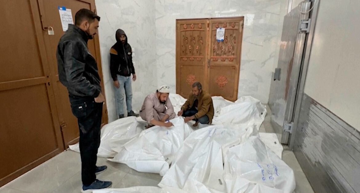 Palestinians gather in a morgue with the bodies of their relatives killed in Israeli airstrikes in the city of Khan Younis, southern Gaza Strip, Friday, Oct. 25, 2024. (AP Photo)