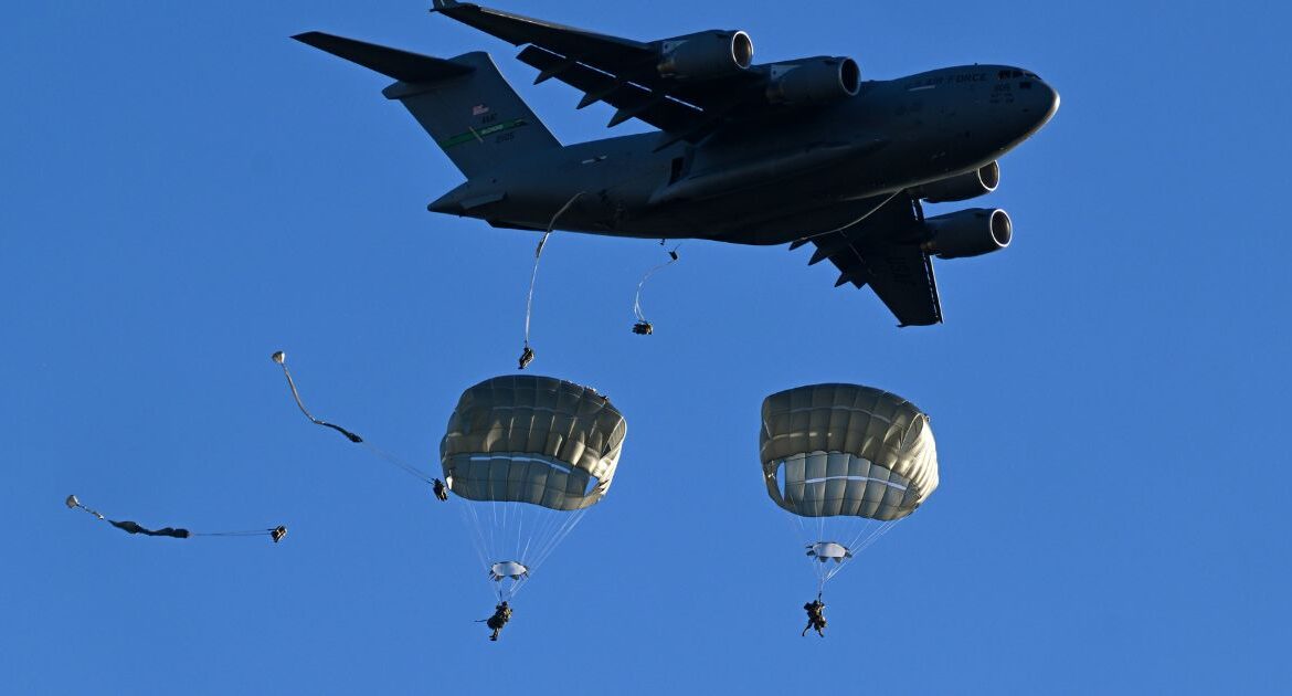 U.S. Army soldiers with the 11th Airborne parachute from a C-17 Globemaster III during a combat training exercise near Mauna Loa, Hawaii, Oct. 7, 2024. The big and cumbersome Army is trying to transform itself to deploy quickly to Asia, in case of a war with China. (Kenny Holston/The New York Times)