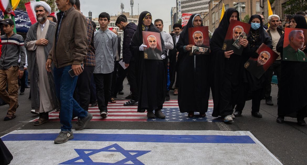 Demonstrators walk over painted images of an American flag and an Israeli flag while marking the 45th anniversary of Iran’s takeover of the U.S. embassy in Tehran, Iran, on Sunday, Nov. 3, 2024. The State Department confirmed that it was looking into reports that an Iranian-American citizen had been arrested in Iran. (Arash Khamooshi/The New York Times)
