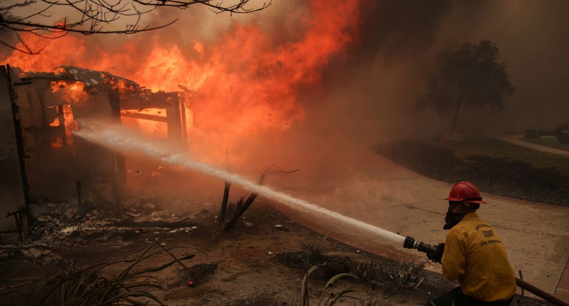 Firefighters spray water on a burning structure during the Mountain Fire, Wednesday, Nov. 6, 2024, near Camarillo, Calif. (AP/Ethan Swope)