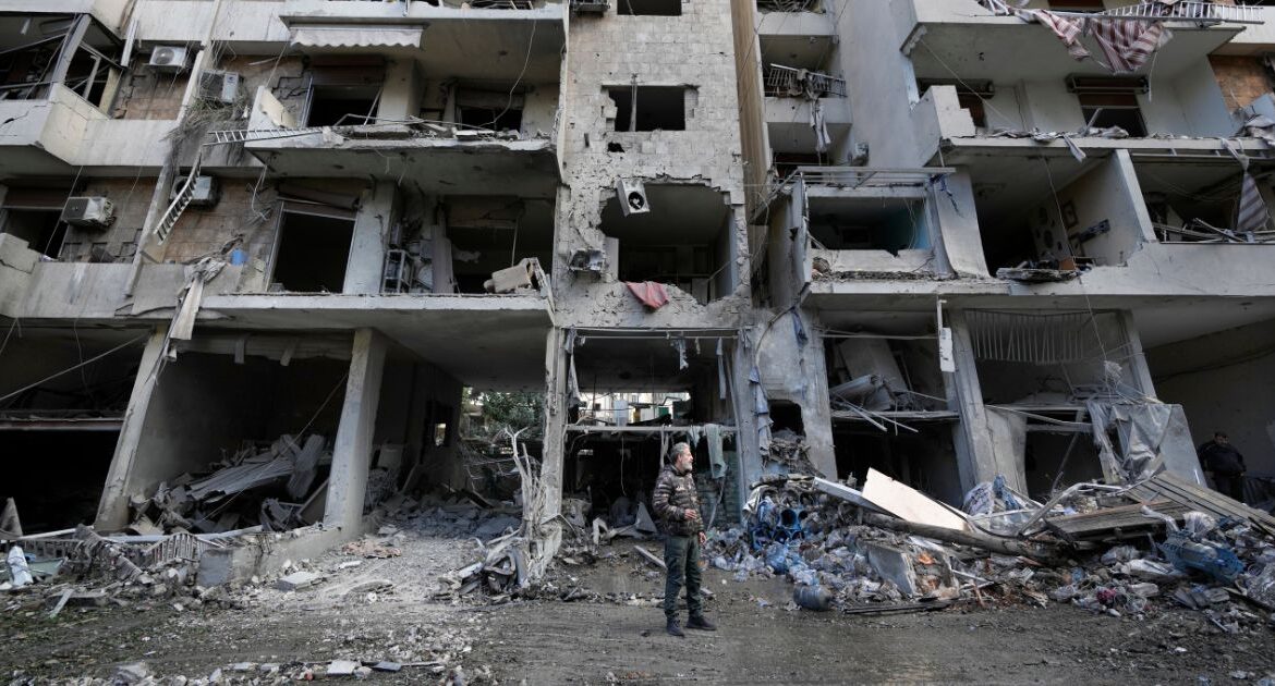 A man stands in front of a destroyed building after Sunday's Israeli airstrike in Dahiyeh, in the southern suburb of Beirut, Lebanon, Monday, Nov. 25, 2024. (AP/Hussein Malla)