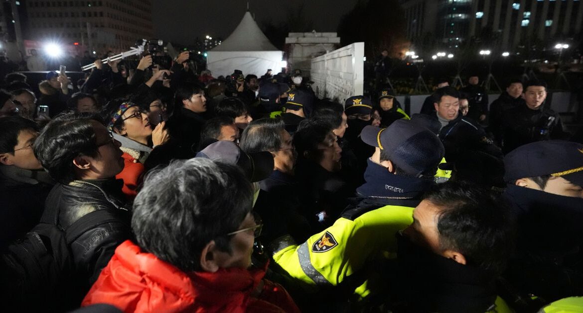 People try to enter as police officers stand guard in front of the National Assembly in Seoul, South Korea, Tuesday, Dec. 3, 2024. (AP/Lee Jin-man)