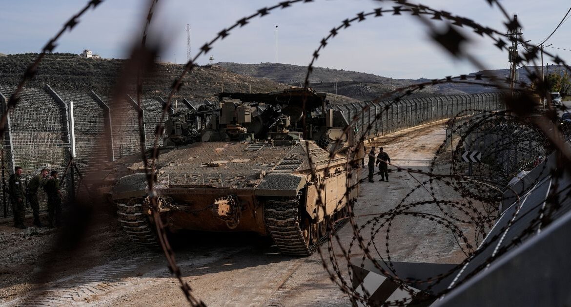 Israeli soldiers stand next to armored vehicles parked near the so-called Alpha Line that separates the Israeli-annexed Golan Heights from Syria, in the town of Majdal Shams, Monday, Dec. 9, 2024. (AP/Matias Delacroix)