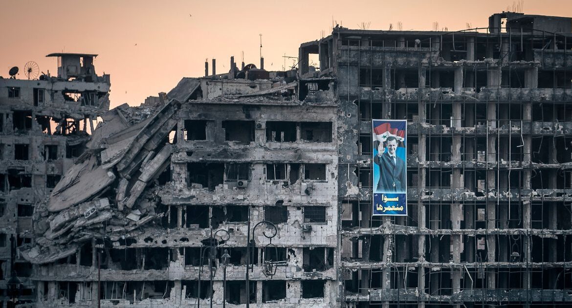 A poster for Syria’s President Bashar al-Assad hangs on a destroyed shopping mall in the war-ravaged city of Homs, Syria, June 15, 2014. (Sergey Ponomarev The New York Times)