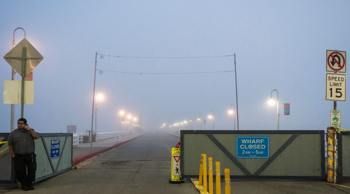 A security guard watches the entrance to the closed Santa Cruz Wharf in Santa Cruz, Calif., Monday, Dec. 23, 2024. (AP/Nic Coury)