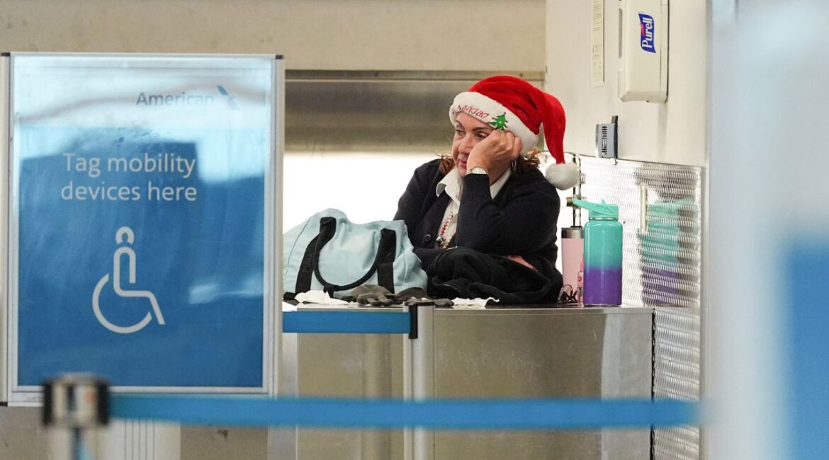 An American Airlines employee wearing a Santa Claus hat looks toward quiet check-in counters in the American terminal at Miami International Airport, on Christmas Eve, Tuesday, Dec. 24, 2024, in Miami. (AP Photo/Rebecca Blackwell)