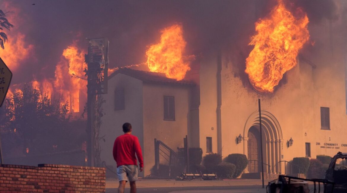 A man walks in front of the burning Altadena Community Church, Wednesday, Jan. 8, 2025, in in Pasadena, Calif. (AP/Chris Pizzello)