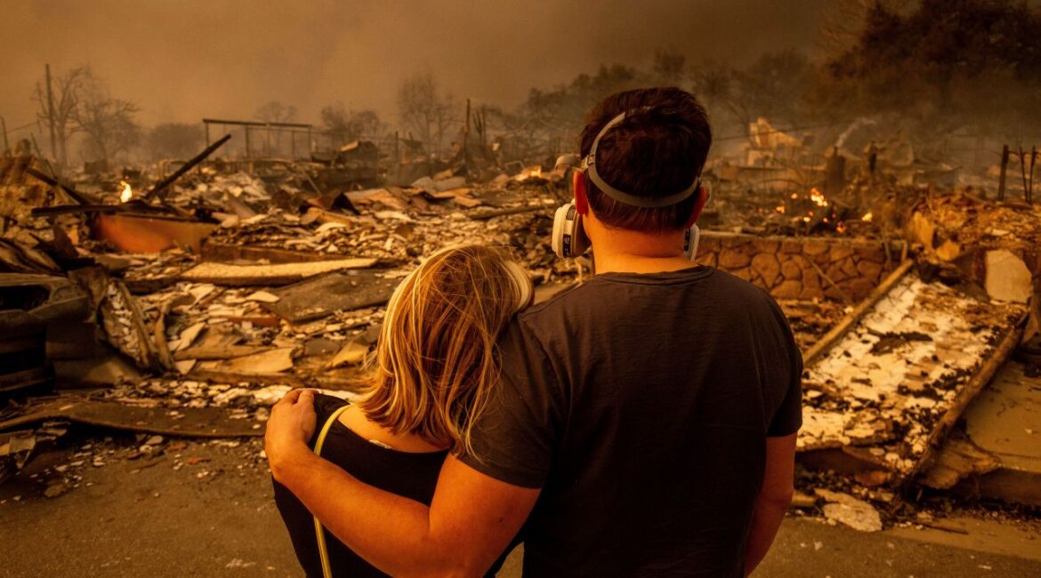 Megan Mantia, left, and her boyfriend Thomas, only first game given, return to Mantia's fire-damaged home after the Eaton Fire swept through, Wednesday, Jan. 8, 2025 in Altadena, Calif. (AP/Ethan Swope)
