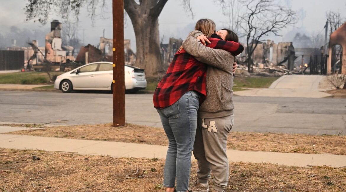 Lisa Diaz hugs a neighbor outside of their homes as the Eaton Fire sweeps through the area Wednesday, Jan. 8, 2025, in Altadena, Calif. (AP/Nic Coury)