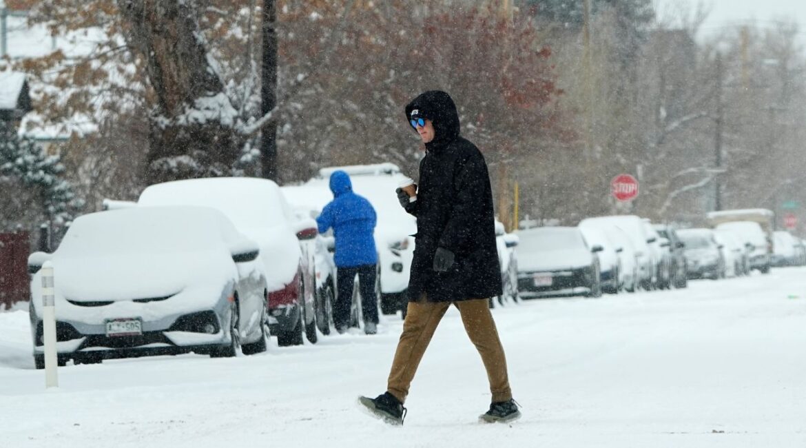 A pedestrian crosses First Avenue as a winter storm sweeps over the intermountain West, plunging temperatures into the single digits and bringing along a light snow in its wake Saturday, Jan. 18, 2025, in Denver. (AP/David Zalubowski)