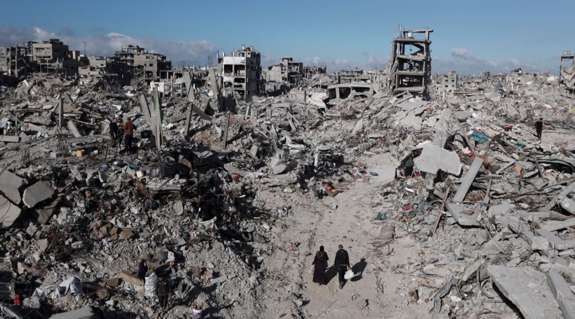 Palestinians walk through the destruction caused by the Israeli air and ground offensive in Jabaliya, a day after the ceasefire deal between Israel and Hamas came into effect, Monday, Jan. 20, 2025. (AP/Abed Hajjar)