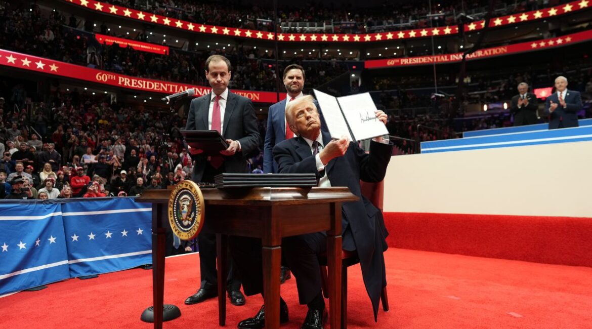 President Donald Trump holds up an executive order after signing it on stage at the Capitol One Arena, following his inauguration in Washington, Jan. 20, 2025. Attorneys general from 18 states sued Trump on Tuesday to block an executive order that refuses to recognize the U.S.-born children of unauthorized immigrants as citizens, contrary to the 14th Amendment. (Doug Mills/The New York Times)