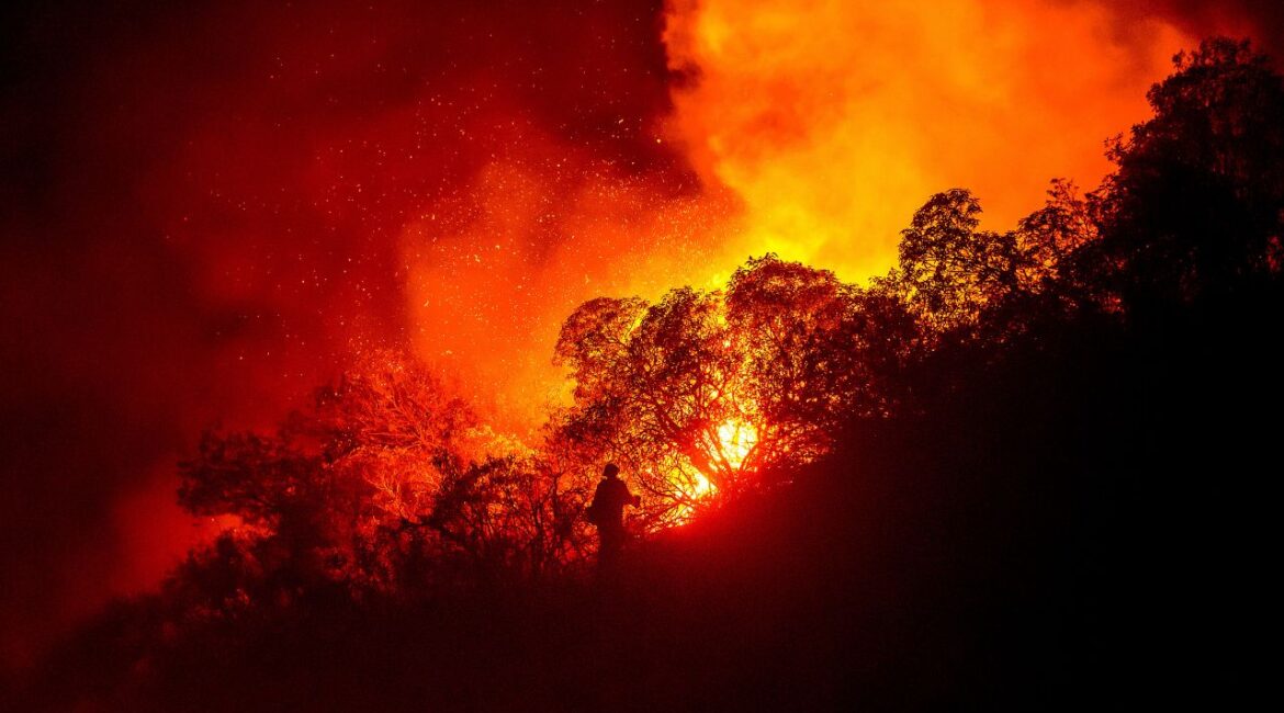 A firefighter battles the Lilac Fire near the Bonsall community of San Diego County, Calif., on Tuesday, Jan. 21, 2025. (AP Photo/Noah Berger)