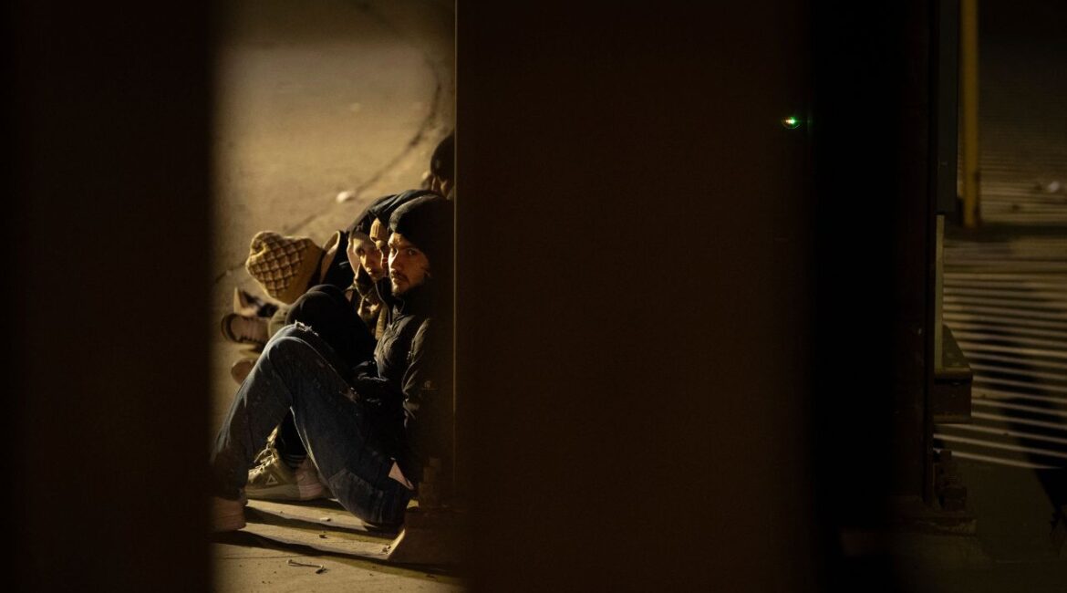 A group of migrants wait to be processed between two border walls separating Mexico and the United States after crossing illegally before dawn Tuesday, Jan. 21, 2025, in San Diego. (AP Photo/Gregory Bull)