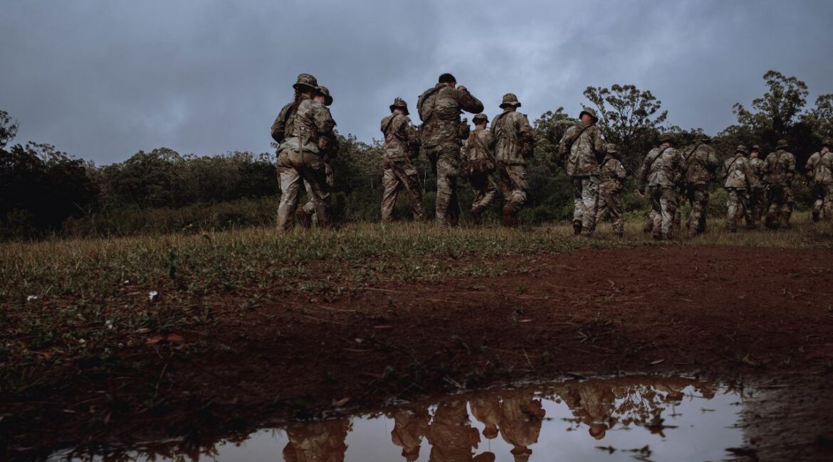 Soldiers at the Army’s jungle training school on Oahu, in Hawaii, practice tactical movements in the pouring rain, Nov. 28, 2023. (Mark Abramson/The New York Times)