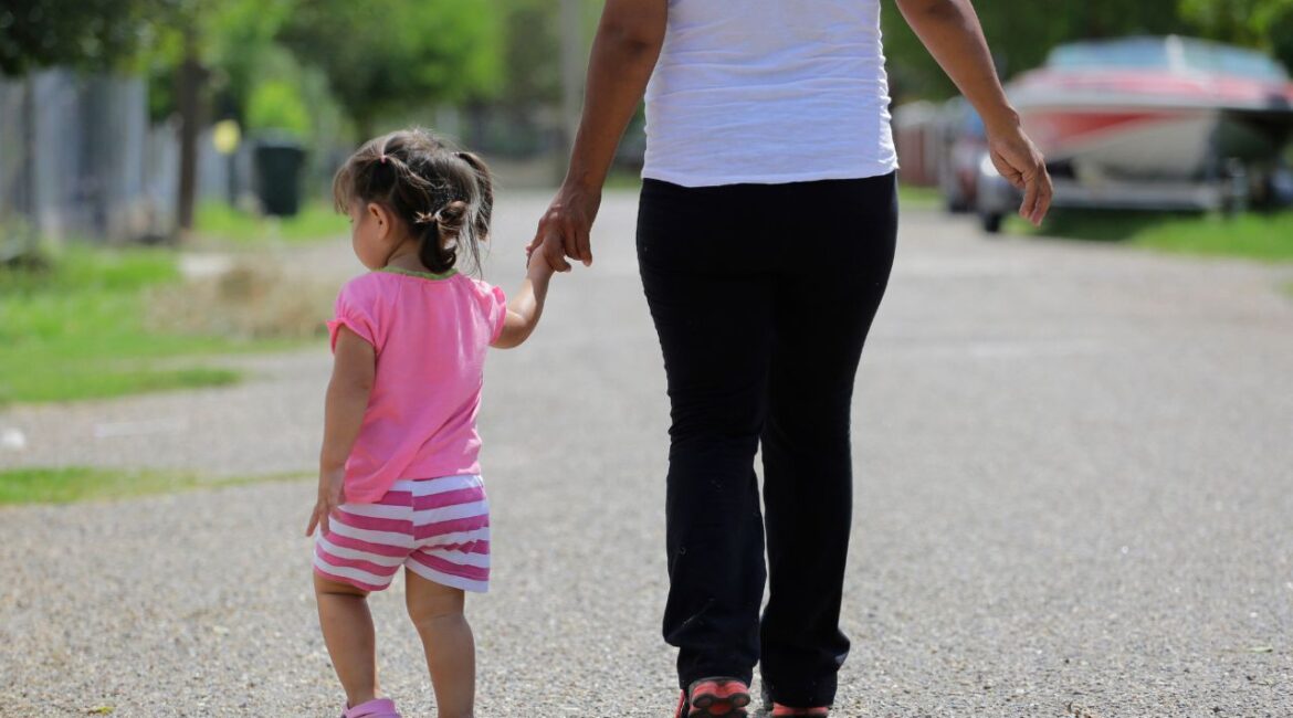 In this Sept. 16, 2015, photo, a woman in Sullivan City, Texas, who said she entered the country illegally, walks with her daughter who was born in the United States, but was denied a birth certificate. (AP File)