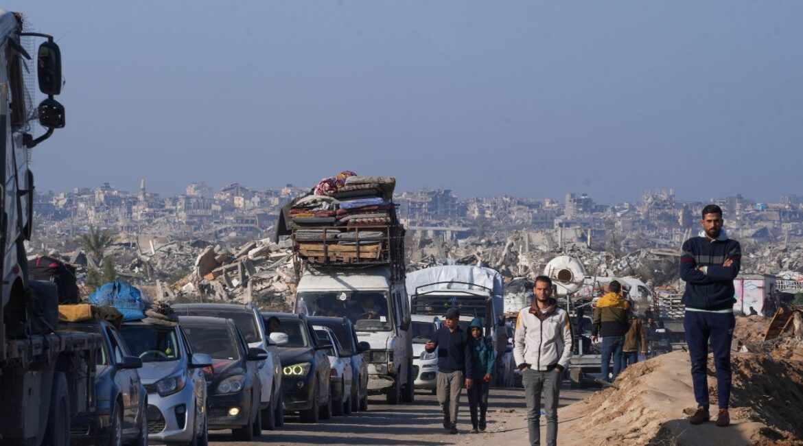 Displaced Palestinians, traveling in vehicles, wait to cross through a security checkpoint at the Netzarim corridor as they make their way from central Gaza to the northern Gaza Strip, Tuesday, Feb. 18, 2025. (AP/Abdel Kareem Hana)