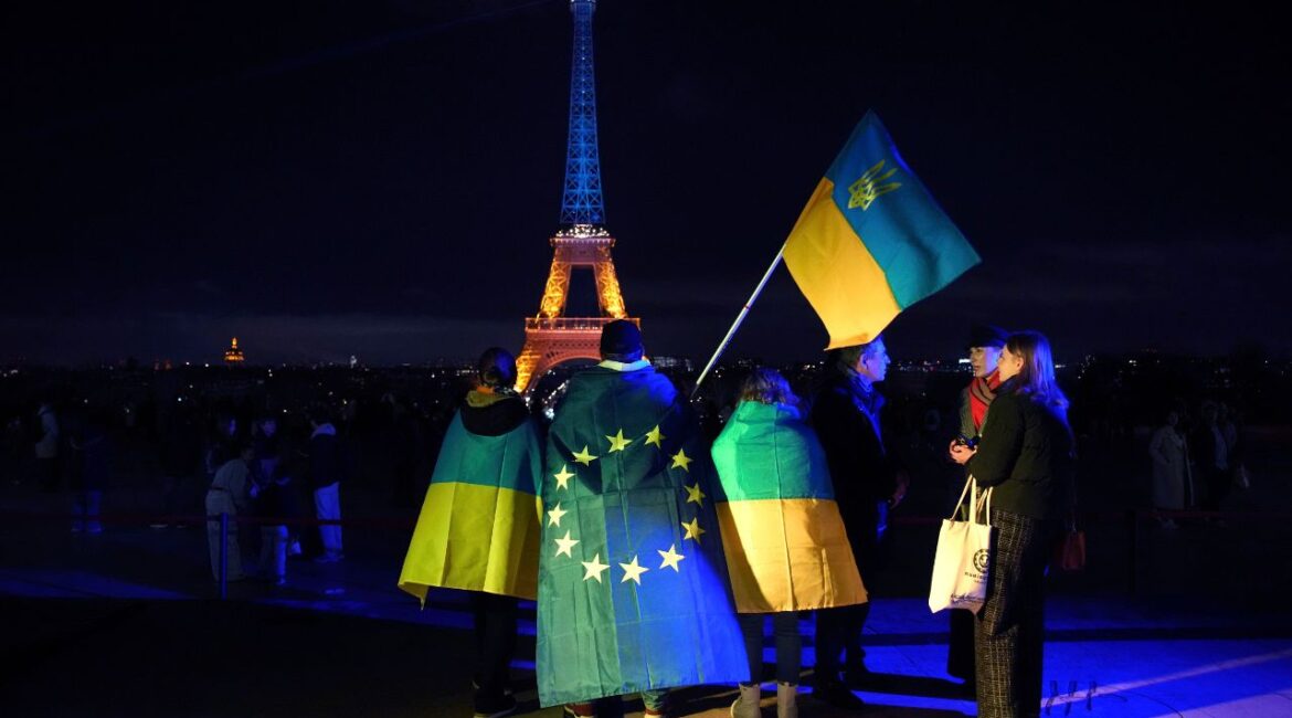 Ukrainians hold Ukrainian and European flag as the Eiffel Tower is illuminated with the colors of Ukraine to mark the third anniversary of Russia's invasion of the country, in Paris, Monday, Feb. 24, 2025. (AP File)