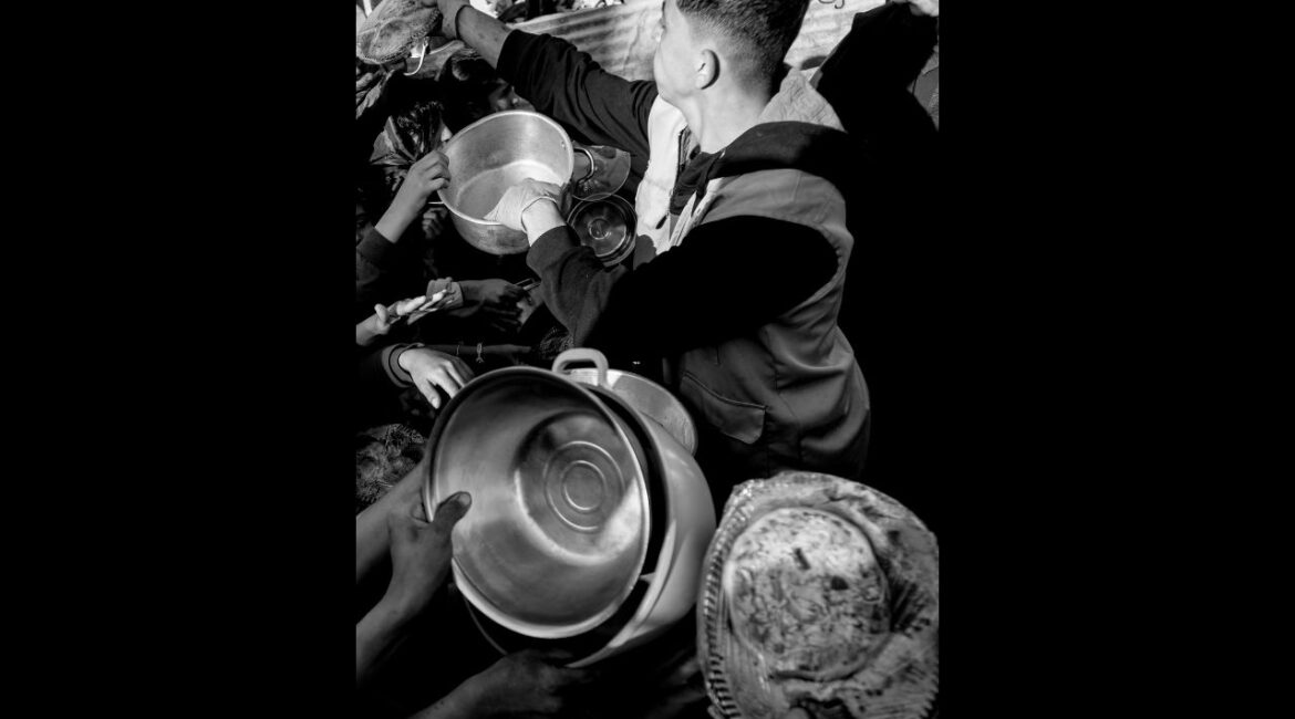 Food is passed out to residents in Beit Lahia, north of the Gaza Strip on March 10, 2025. (Saher Alghorra/The New York Times)