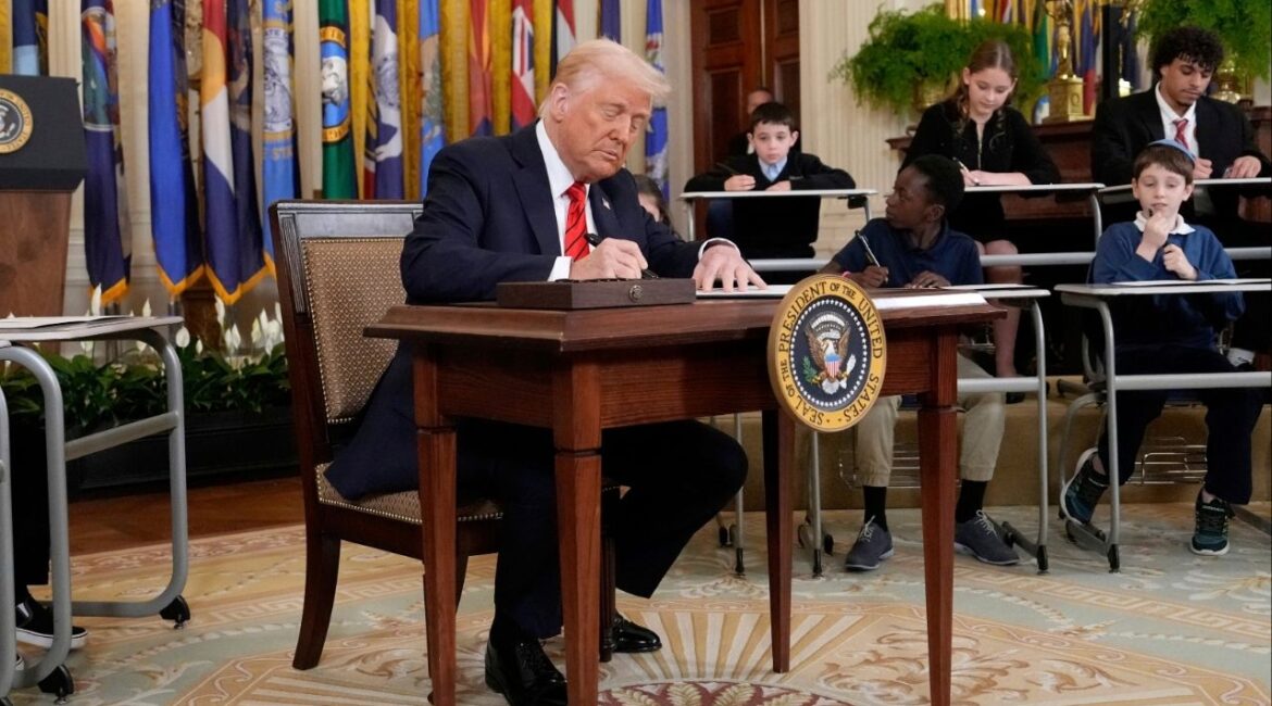 President Donald Trump signs an executive order in the East Room of the White House in Washington, Thursday, March 20, 2025. (AP/Ben Curtis)