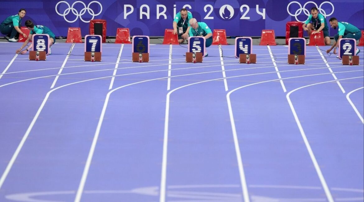 Staff members prepare the start line at Stade de France in Paris during the 2024 Summer Olympics, Aug. 3, 2024. Track and field will introduce mandatory DNA sex testing for athletes entering female competitions, its global leader said on Tuesday, March 25, 2025, making it the first Olympic sport to add the requirement. (Chang W. Lee/The New York Times)