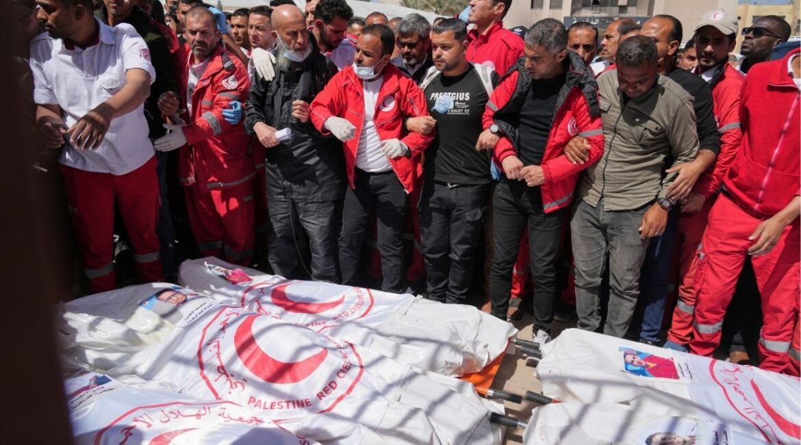 Mourners gather around the bodies of 8 Red Crescent emergency responders, recovered in Rafah a week after an Israeli attack, as they are transported for burial from a hospital in Deir al-Balah, Gaza Strip, on Monday, March 31, 2025. (AP/Abdel Kareem Hana)