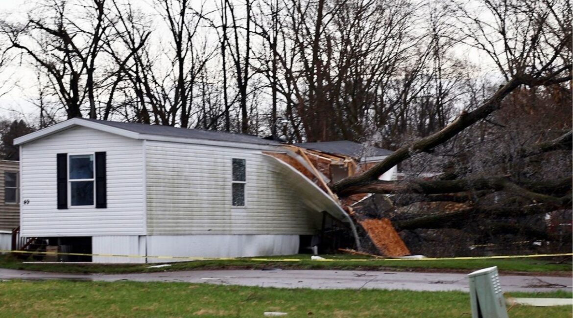 A large tree rests on top of a mobile home at Millwood Estates on East Cork Street after a storm Sunday, March 30, 2025, in Kalamazoo, Mich. (Brad Devereaux/Kalamazoo Gazette via AP)