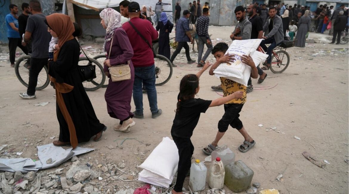 Palestinians receive bags of flour and other humanitarian aid distributed by UNRWA, the U.N. agency helping Palestinian refugees in Jabaliya, Gaza Strip on Tuesday, April 1, 2025. (AP/Jehad Alshrafi)