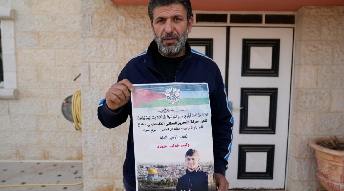 Khalid Ahmad holds a poster of his 17-year-old son, Waleed, who died in an Israeli prison, that reads in Arabic, "The hero prisoner Martyr, mercy and eternity for our righteous Martyrs," in the West Bank town of Silwad, northeast of Ramallah Wednesday, March 26, 2025. (AP/Nasser Nasser)