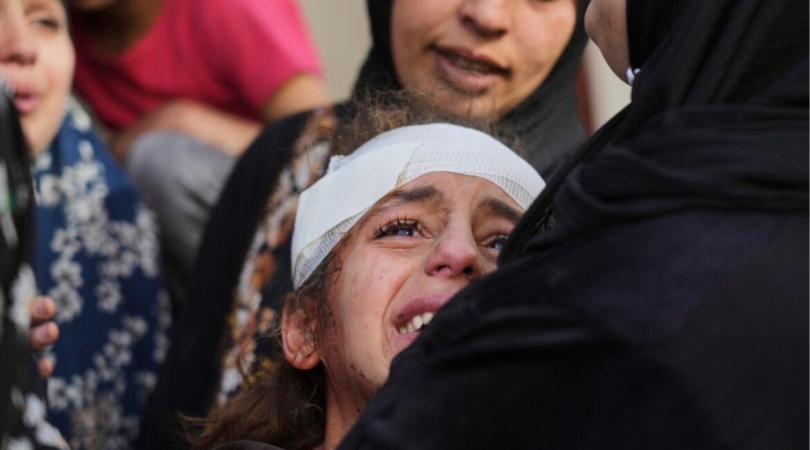 Yamama Jundia, 13, injured in an Israeli airstrike, grieves alongside others over the bodies of their relatives, who were killed in the same strike, at the Baptist Hospital in Gaza City on Thursday, April 3, 2025. (AP/Jehad Alshrafi)