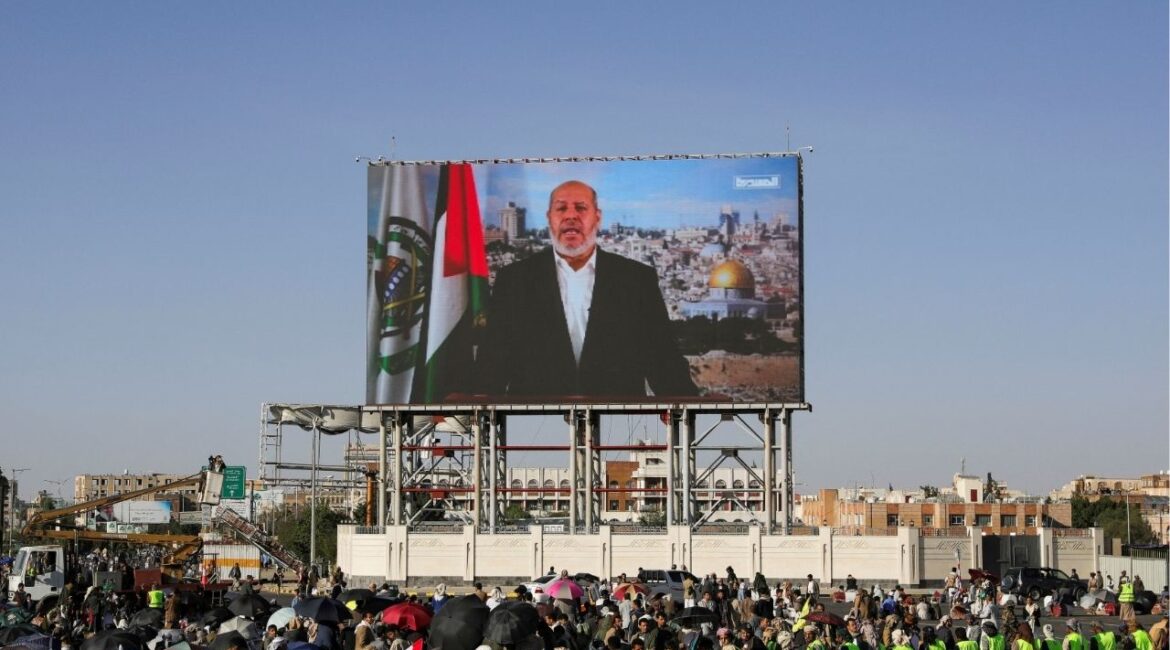 Protesters, mainly Houthi supporters, stand near a screen displaying Senior Hamas official Khalil al-Hayya during a rally to show support to Lebanon's Hezbollah and Palestinians in the Gaza Strip, in Sanaa, Yemen October 18, 2024. (REUTERS File)