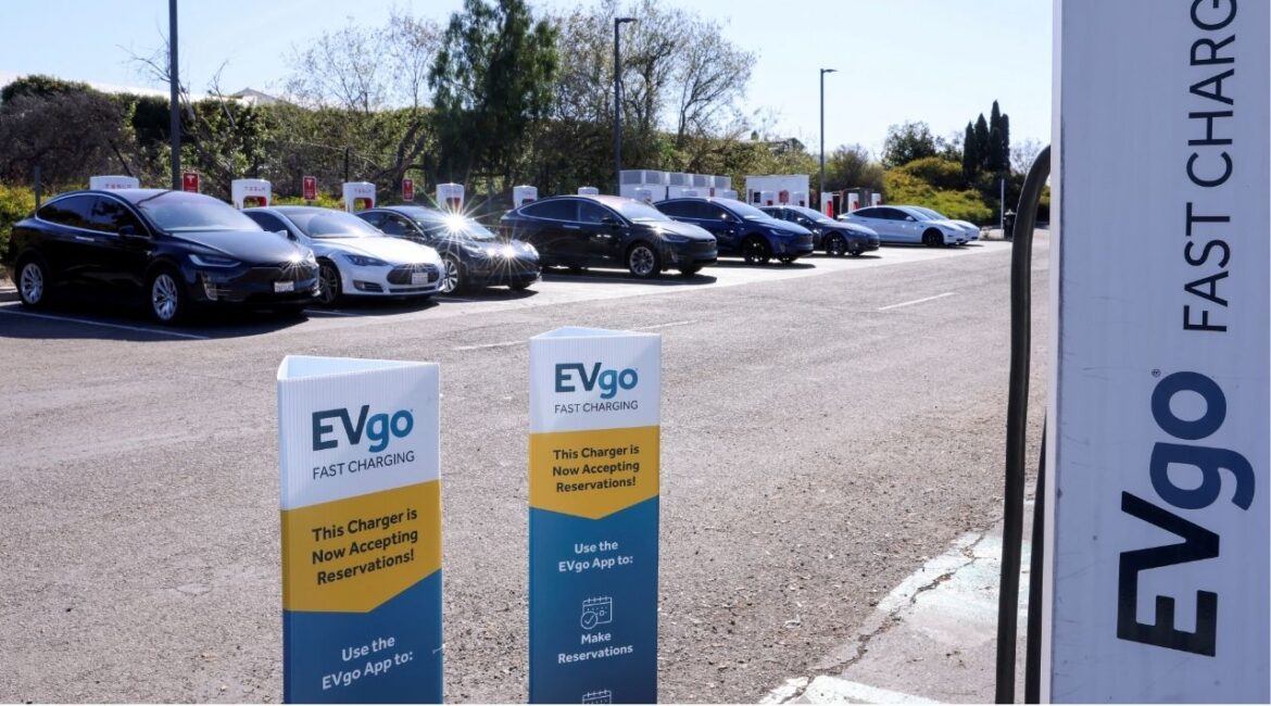 People charge their electric cars at a Tesla super charging station next to an EVgo electric charging location in Carlsbad, California, U.S., March 7, 2022. (REUTERS/Mike Blake)