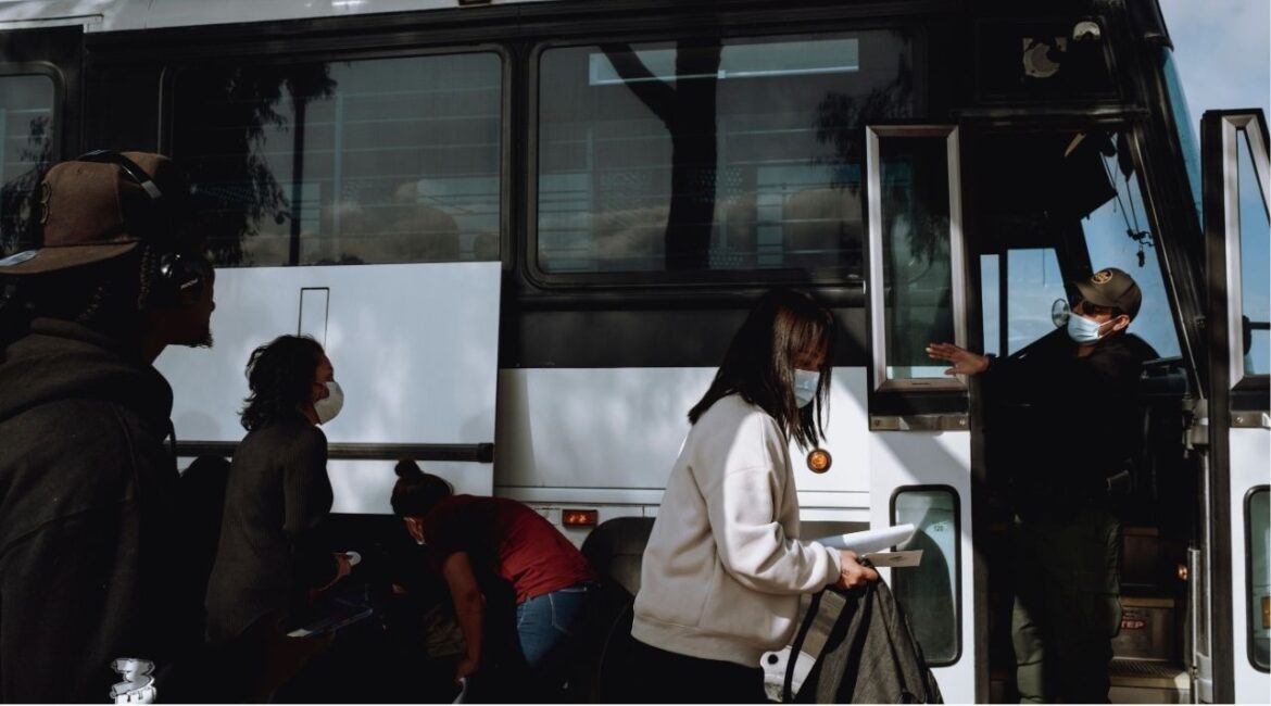 Migrants seeking asylum board a bus headed for a local transit center in San Diego, May 23, 2024. At least 25 cities and counties in California have declared themselves sanctuaries for undocumented immigrants by passing laws that limit how much they will cooperate with federal efforts to deport people. (Mark Abramson/The New York Times)