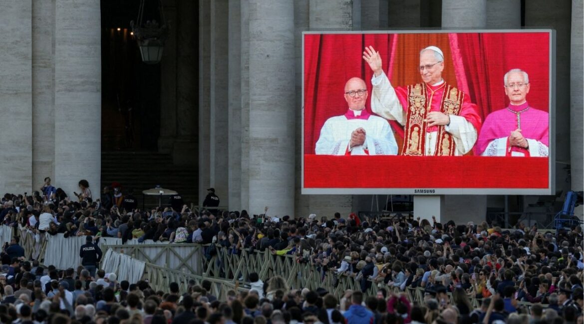 People watch as newly elected Pope Leo XIV, Cardinal Robert Prevost of United States, shown on screen, appears on the balcony of St. Peter's Basilica, as seen from Rome, Italy May 8, 2025. REUTERS/Alkis Konstantinidis