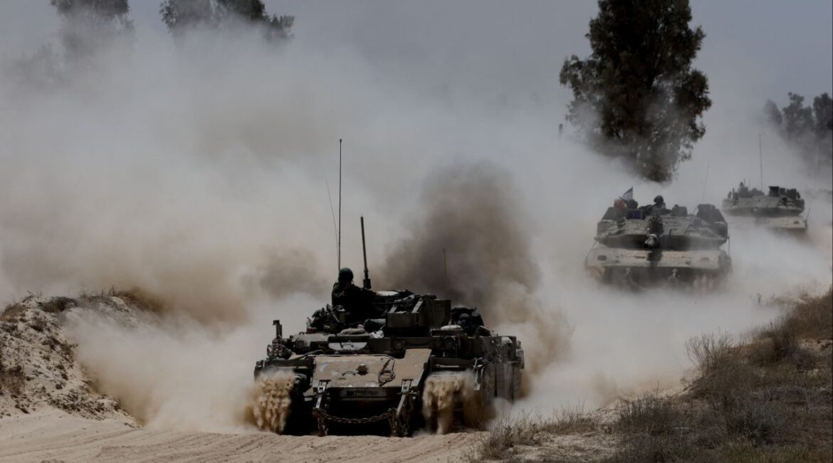 Military vehicles drive their way from the Israeli side of the Israel-Gaza border into Gaza, as seen from Israel, May 20, 2025. REUTERS/Amir Cohen