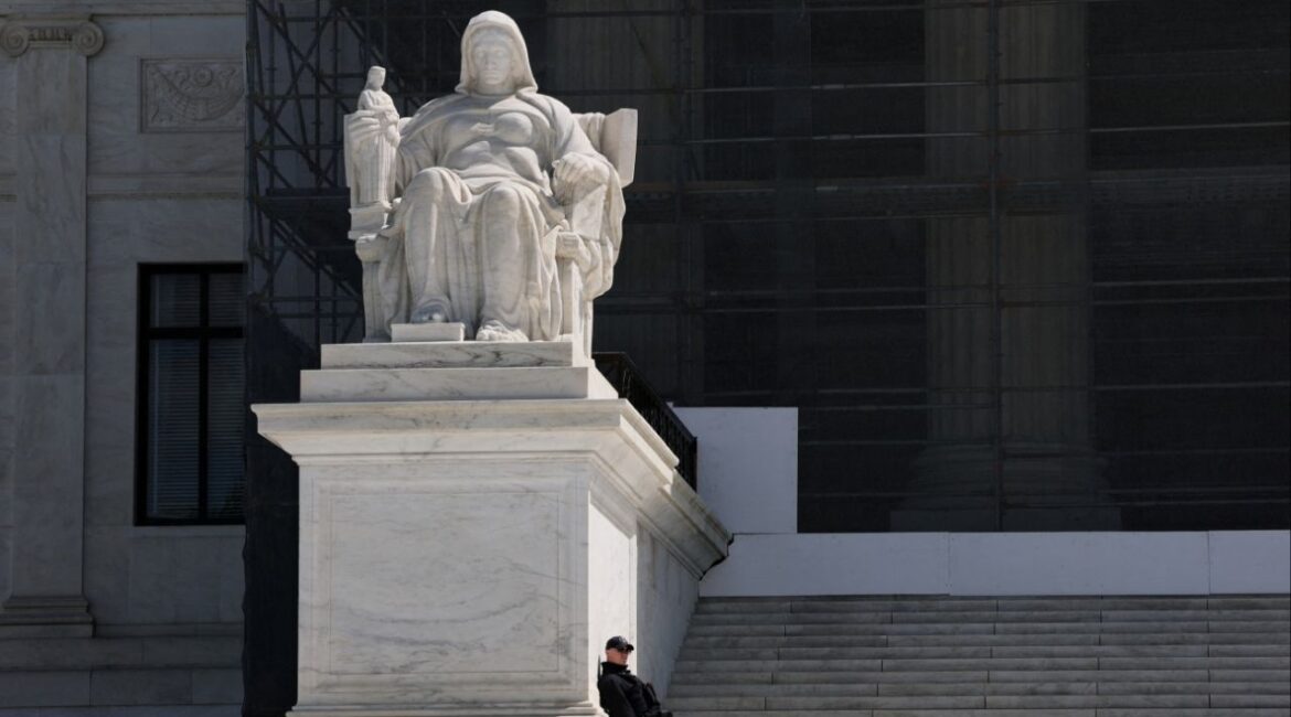 A U.S. Supreme Court Police officer leans against the statue titled the Contemplation of Justice along the front steps of the U.S. Supreme Court building in Washington, D.C., U.S., April 8, 2025. REUTERS/Jonathan Ernst/File Photo