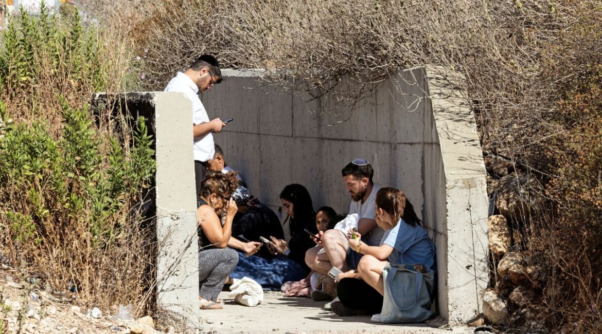 Israelis take shelter at the side of a highway as siren sounds following missile attack from Iran on Israel, in central Israel June 15, 2025. REUTERS/Oren Ben Hakoon