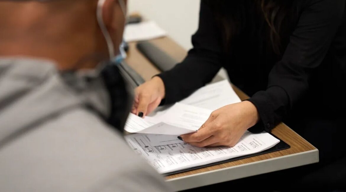 Benefits counselor Perla Lopez assists an undocumented adult at St. John’s Community Health in Los Angeles in December of 2023. (Photo by Lauren Justice for CalMatters)
