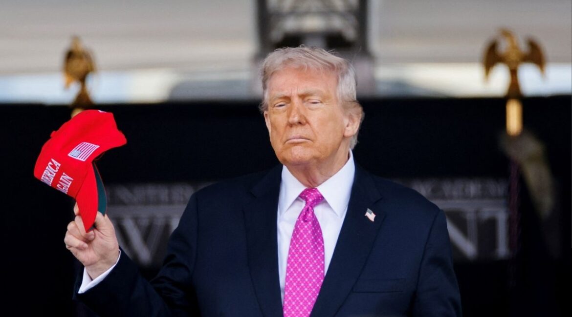 U.S. President Donald Trump holds a 'Make America Great Again' (MAGA) hat as he attends the commencement ceremony at West Point Military Academy in West Point, New York, U.S., May 24, 2025. REUTERS/Eduardo Munoz/File Photo