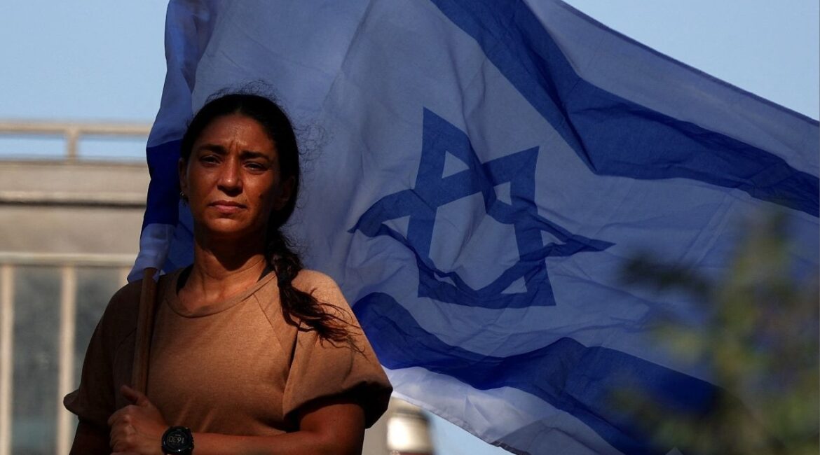 A mourner holds an Israeli flag, ahead of the funeral of Israeli soldier Sergeant Maayan Baruch Pearlstein, who was killed amid the ongoing conflict in Gaza between Israel and Hamas, in Misgav, Israel, June 25, 2025. (Reuters/Florion Goga)