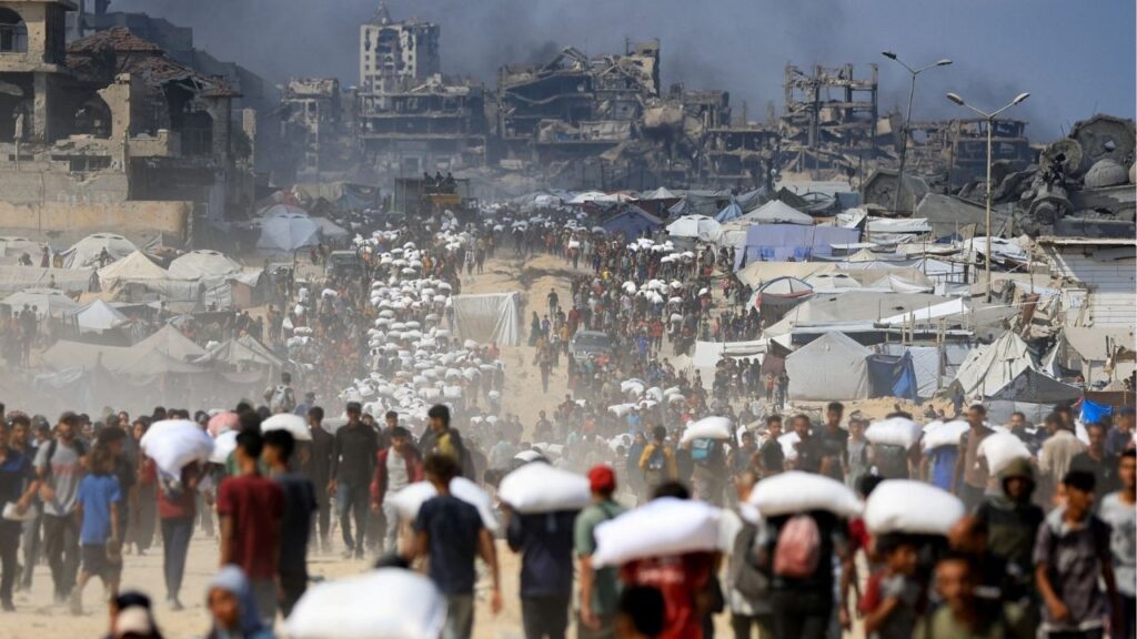 Palestinians gather as they carry aid supplies that entered Gaza through Israel, amid a hunger crisis, in Beit Lahia in the northern Gaza Strip July 20, 2025. REUTERS/Dawoud Abu Alkas