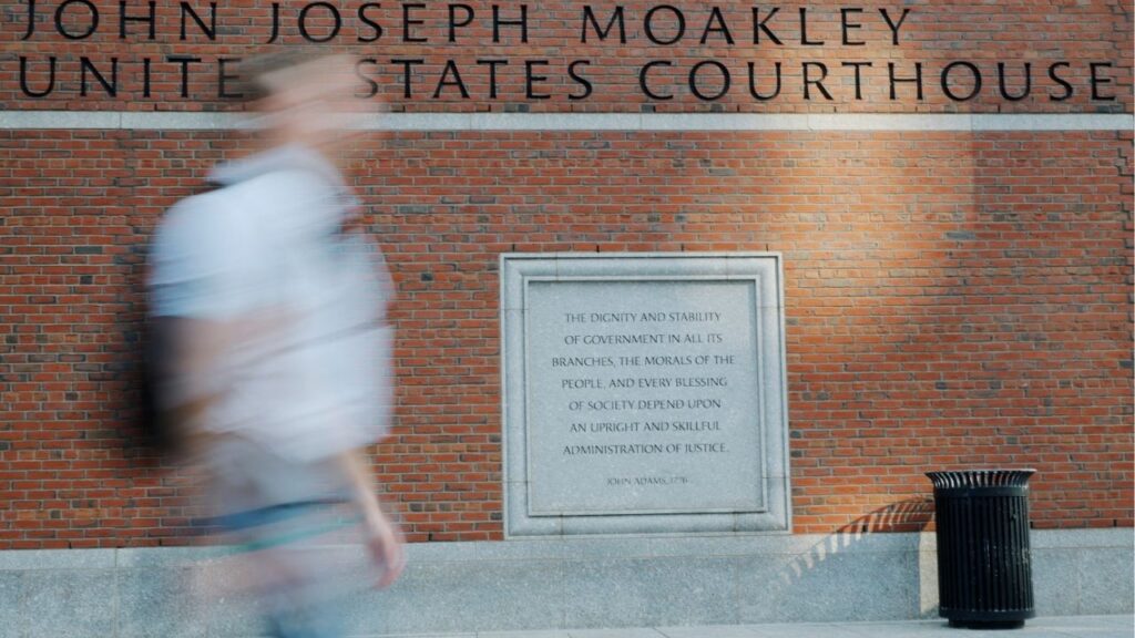 A pedestrian passes the federal courthouse where Harvard University is urging a federal judge to order U.S. President Donald Trump's administration to restore about $2.5 billion in canceled federal grants and cease efforts to cut off research funding, in Boston, Massachusetts, U.S., July 21, 2025. (Reuters/Brian Snyder)